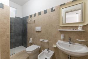 a bathroom with a sink and a toilet and a mirror at Calanca Apulian Residence in Torre Santa Sabina