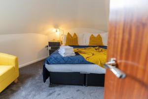 a bedroom with a bed with yellow and blue sheets at Cosy flat with Modern Luxuries in Sheffield