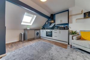 a kitchen and living room with a couch and a window at Cosy flat with Modern Luxuries in Sheffield