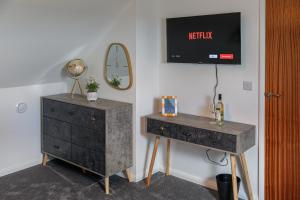 a bedroom with a dresser and a nightstand and a mirror at Cosy flat with Modern Luxuries in Sheffield