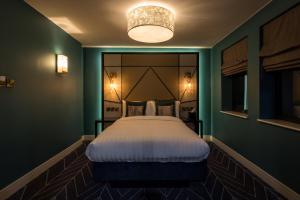 a bedroom with a large bed in a green room at Seven Hotel in Southend-on-Sea