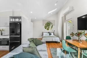 uma sala de estar com um sofá, uma mesa e uma cama em WILL56 - Gumtree Studio em Perth