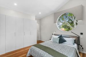 - une chambre avec un grand lit et une fenêtre ronde dans l'établissement WILL56 - Gumtree Studio, à Perth