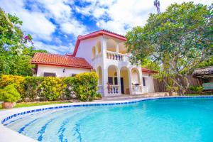 a large swimming pool in front of a house at Banana House Villas in Watamu