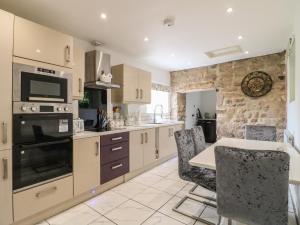 a kitchen with a table and a stove top oven at Midway Cottage in Matlock