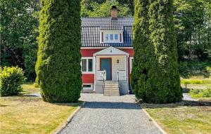 een rood-wit huis tussen twee bomen bij Nice Home In Edsbruk With Kitchen in Edsbruk