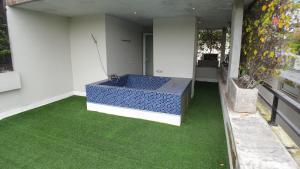 Ecoloft Jababeka Golf في Pegadungan: غرفة مع حوض استحمام أزرق على أرضية خضراء