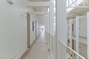 a corridor of a hospital with white walls at Calanca Apulian Residence in Torre Santa Sabina