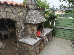 un forno in pietra in un patio con cancello di Lavanda Apartments&Studios a Pinezići