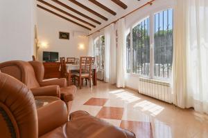 sala de estar con sillas, mesa y ventana en Casa Ceba, en Jávea