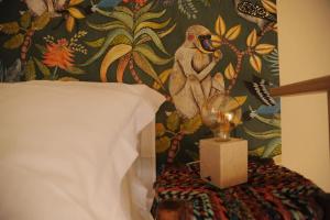 Un dormitorio con papel pintado con un mono en la pared en Un rifugio bohémien en Turín