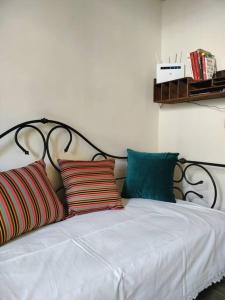 uma cama com quatro almofadas com uma moldura preta em Un rifugio bohémien em Turim