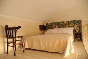 um quarto com uma cama e uma cadeira num quarto em Un rifugio bohémien em Turim