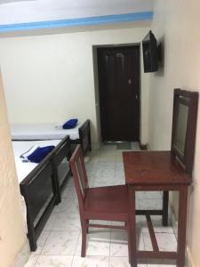 a room with a table and a room with two beds at B Hostel in Fort Kochi