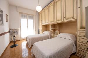 1 Schlafzimmer mit 2 Betten, einem Ventilator und einem Fenster in der Unterkunft 175 - Casa Foglia ,100 meters to sea and beach in Sestri Levante