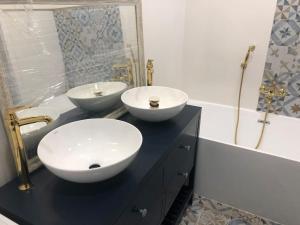 two sinks on a black counter in a bathroom at Zaciszny dom in Szczecin