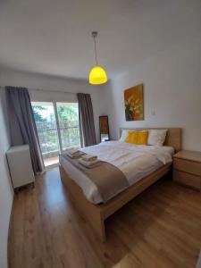 a bedroom with a large bed and a large window at Palm Beach Apartment 26 in Limassol