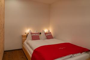 Un dormitorio con una manta roja en una cama en Risa, en Arosa