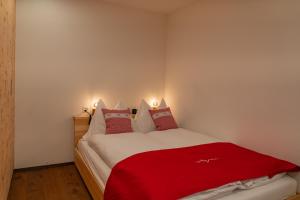 a bedroom with a red blanket on a bed at Risa in Arosa