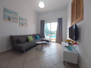 un soggiorno con divano e TV di Palm Beach Apartment 26 a Limassol