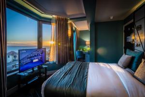a hotel room with a large bed and a large window at Seven Hotel in Southend-on-Sea
