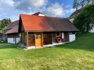 ein Haus mit einem orangenen Dach mit einem Kranz darauf in der Unterkunft Camping f Selbstversorger Gut Jägerhof in Semriach