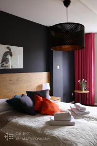 - une chambre avec un grand lit et des oreillers colorés dans l'établissement Keller Apart K12 - Taras z widokiem na wyłączność i klimatyzacją GRATIS, à Porąbka
