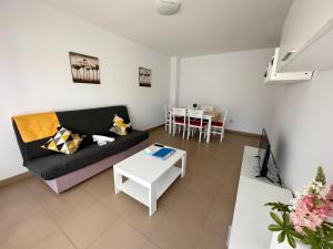 een woonkamer met een bank en een tafel bij Apartamentos Alcocebre Suites 3000 in Alcossebre