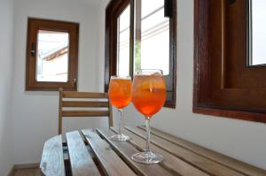twee glazen sinaasappelsap zittend op een houten tafel bij K rooms old town self check in in Zadar