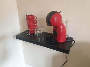 une étagère noire avec un mixeur rouge sur elle dans l'établissement Chez Cerise, à Tournay