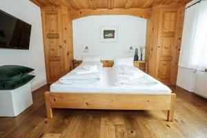 ein Schlafzimmer mit einem Bett in einem Holzzimmer in der Unterkunft Casa LA RODA in Sedrun