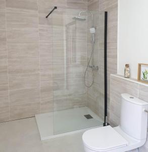 a bathroom with a shower with a toilet and a shower head at Chez Cerise in Tournay