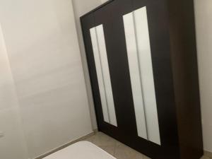 ein Bad mit einer schwarzen und weißen Tür in der Unterkunft H Apartment Vlorë in Vlorë