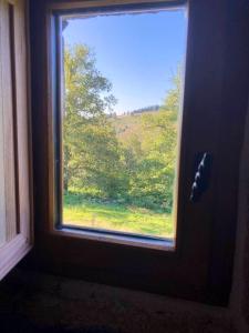 een raam in een kamer met uitzicht op een bos bij Maison de 2 chambres avec jardin amenage et wifi a Chaumeil in Chaumeil