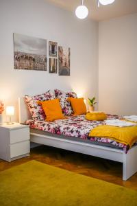 een slaapkamer met een bed met kleurrijke kussens bij Ultracentral Golden Gatehouse 3 Bdrm in Boekarest