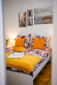 een slaapkamer met een bed met oranje kussens bij Ultracentral Golden Gatehouse 3 Bdrm in Boekarest