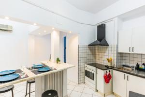 a kitchen with white cabinets and blue plates on the counter at Ultracentral Golden Gatehouse 3 Bdrm in Bucharest