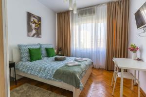 - une chambre avec un lit et des oreillers verts dans l'établissement Ultracentral Golden Gatehouse 3 Bdrm, à Bucarest