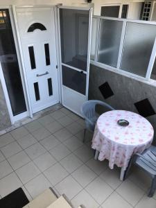 a patio with a table and chairs and a white door at AZALEA HOTEL in Sarti