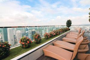 a row of chairs on a balcony with flowers at #5 KLCC Platinum Suites (Face Suites) 2BED 2BATH in Kuala Lumpur