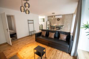 een woonkamer met een zwarte bank en een tafel bij LA FABRIQUE - Centre ville - Climatisation in Saint-Étienne