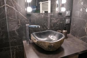 een badkamer met een grote stenen wastafel en een spiegel bij LA FABRIQUE - Centre ville - Climatisation in Saint-Étienne +10 foto's