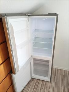 um frigorífico vazio com a porta aberta num quarto em FMI13Furnished Accommodation em Königstädten