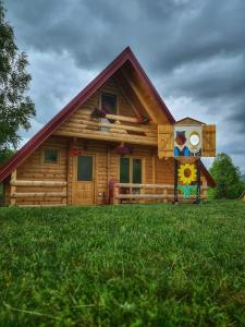 uma casa de madeira com um quadro na frente. em Nika em Nova Varos