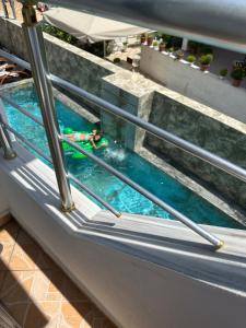 a person swimming in a swimming pool on a building at Ilio Boutique Hotel in Ksamil