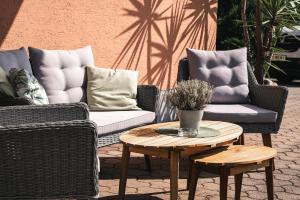 two wicker chairs and a coffee table on a patio at Hotel Kärntnerhof Velden by S4Y in Velden am Wörthersee