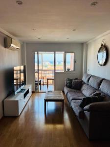 een woonkamer met een bank en een tafel bij 3 Bedrooms Apt WITH THE SEA VIEW in Málaga
