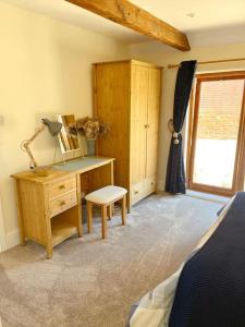 a bedroom with a desk and a bed and a window at Barons Granary , The Bull Pen in Iden