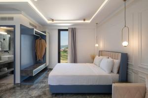 una camera con un letto blu e bianco e una finestra di ACROPOL GOLDEN SUITES a Néos Marmarás