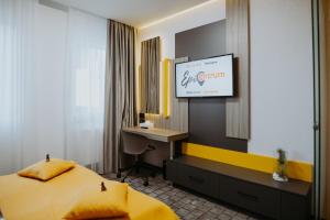 ein Hotelzimmer mit einem Bett und einem TV in der Unterkunft Hotel Epic Centrum in Cisnădie